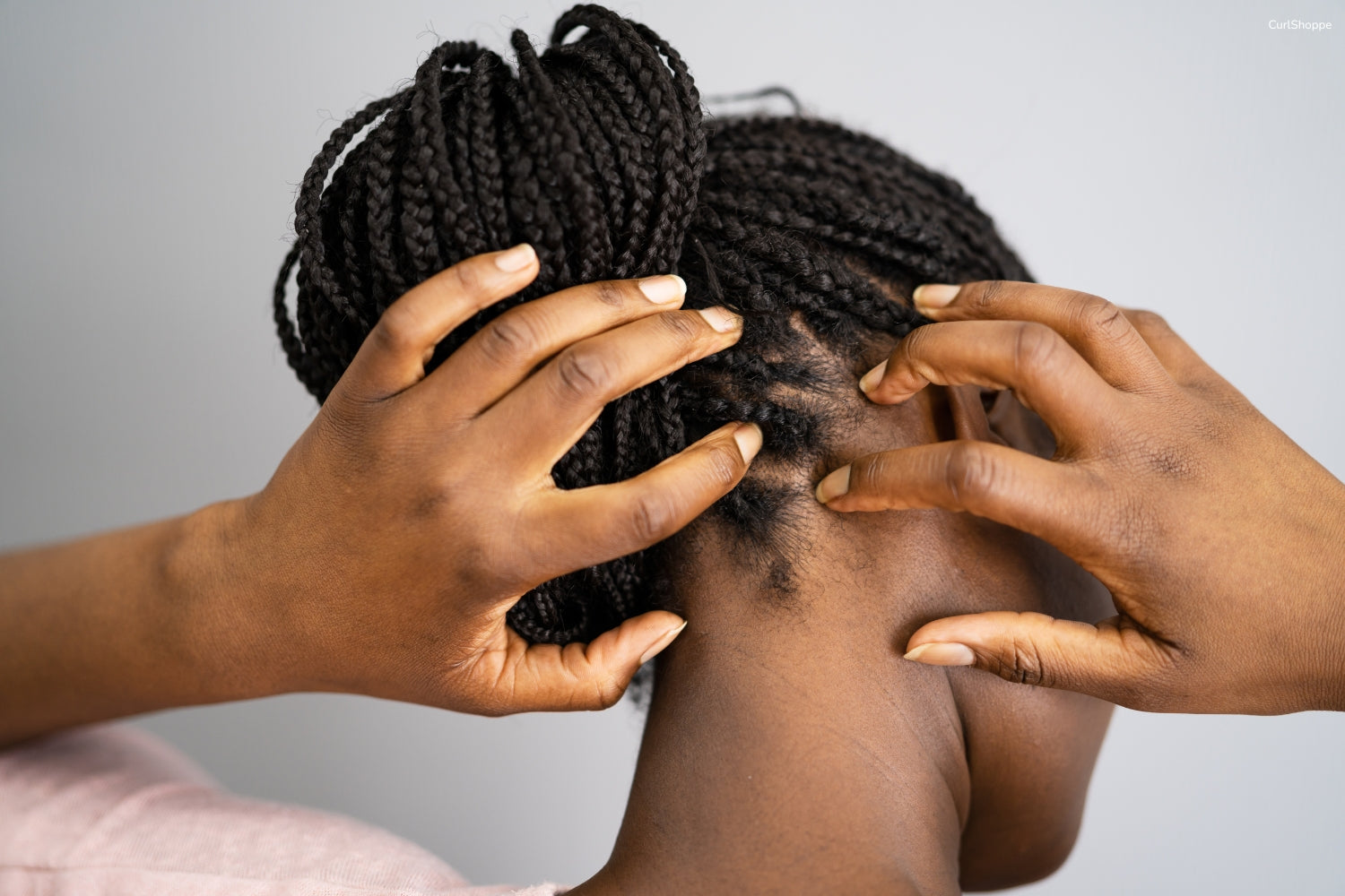 A woman with braids itching scalp