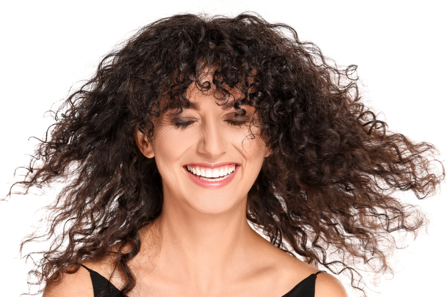 A smiling woman with different curl patterns